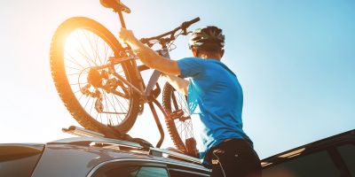 Radfahrer hebt sein Fahrrad auf den Dachträger