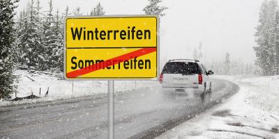 Ein Auto fährt in einer Schneelandschaft über eine Landstrasse